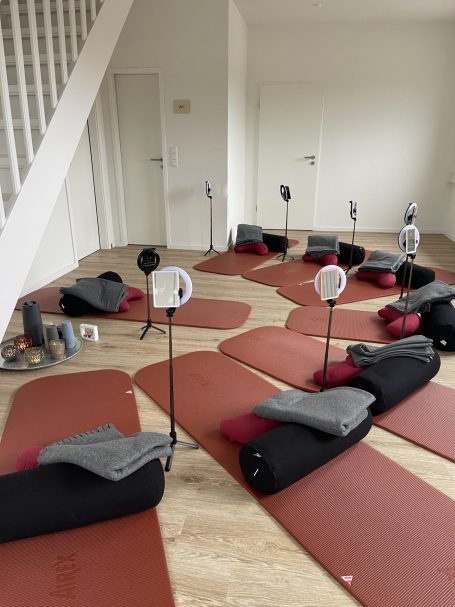 Face Yoga Kurs Physio am Kreisel Duvenstedt Ein Raum mit Yogamatten, Bolstern, Decken und Spiegeln auf Stativen, im Halbkreis angeordnet